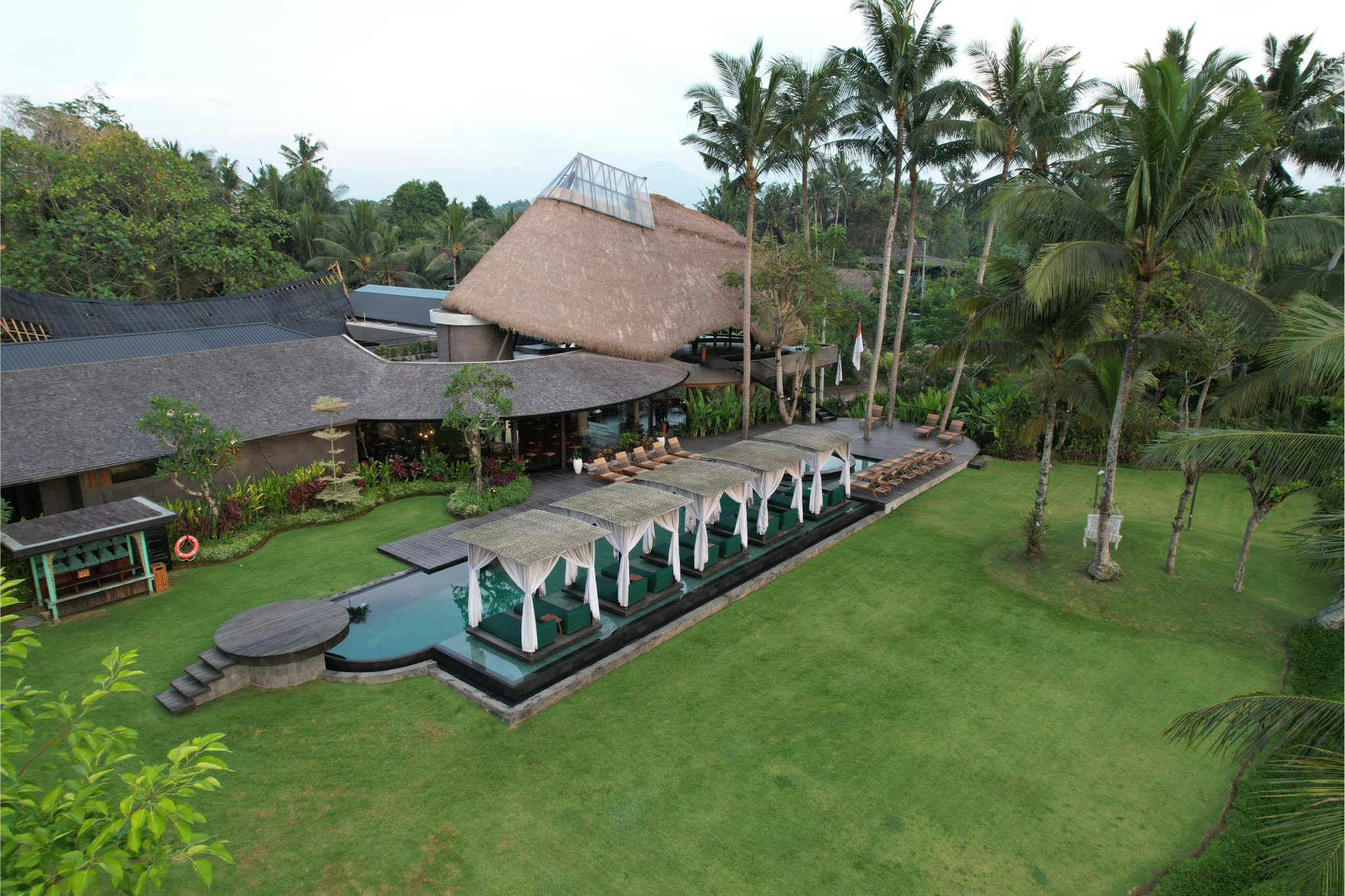 Coworking space in Canggu with young people working and surfing boards nearby

