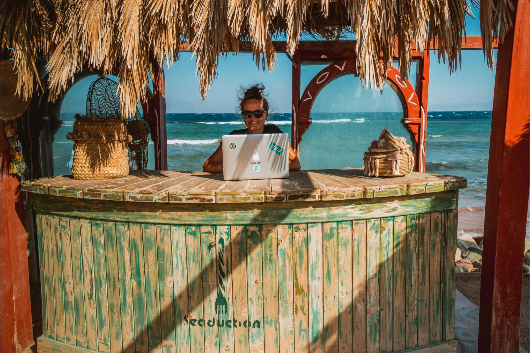 Digital nomad working remotely on a laptop in a tropical outdoor setting