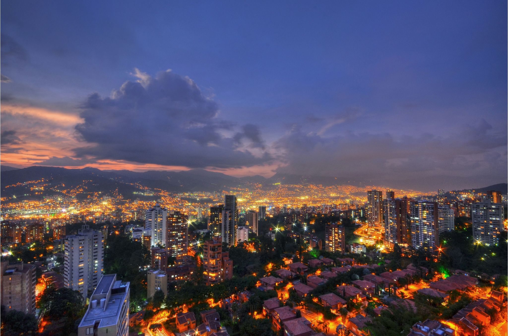 View of Medellín’s cityscape with cable cars and green mountains in the background

