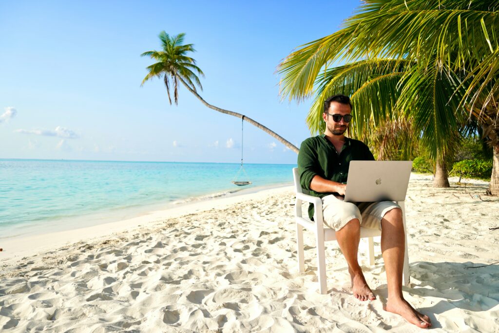 Digital nomad working with laptop outdoors near the beach