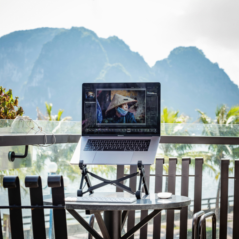 remote worker using a laptop on a rooftop terrace with mountains behind